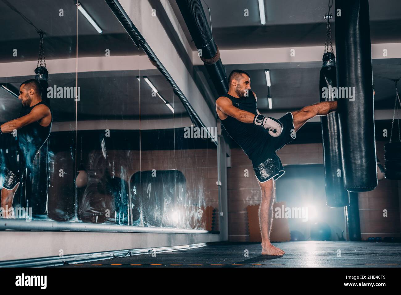 Boxer man during boxing hitting heavy bag at training fitness gym Stock