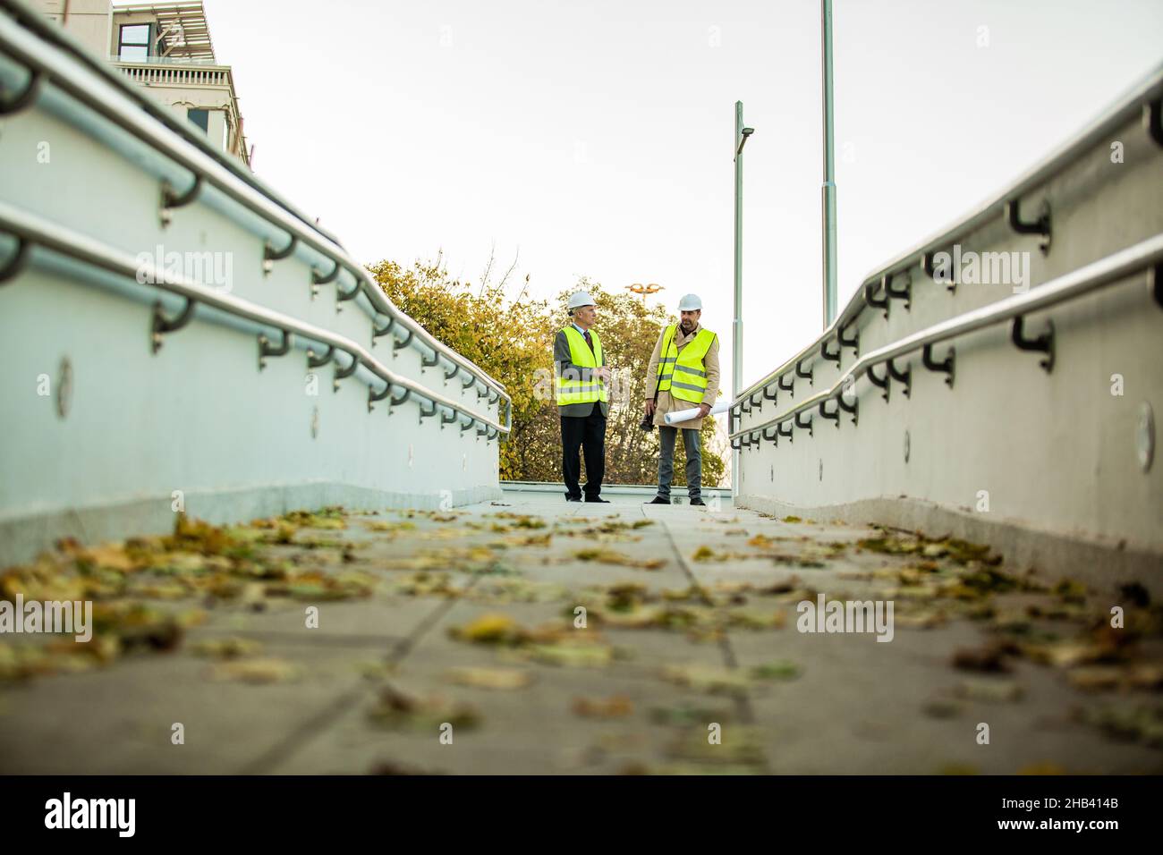 Two senior construction managers are standing and having a conversation Stock Photo