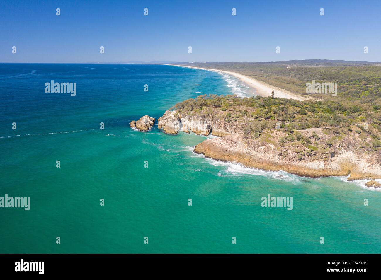 Beautiful aerial view of blue pristine water with surfers and gentle waves Stock Photo