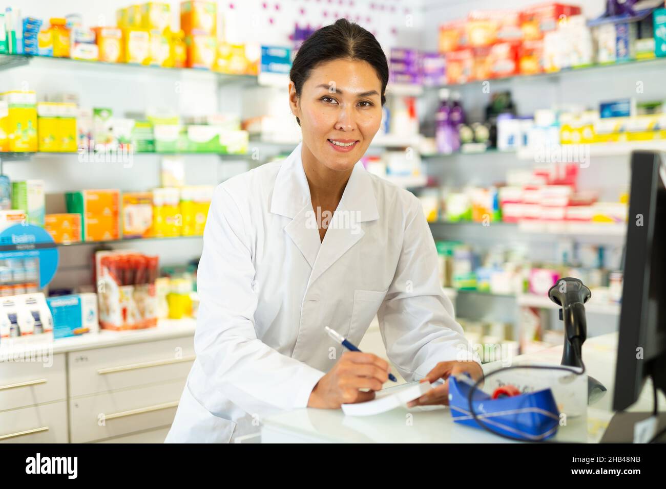Female doctor standing at counter and writing Stock Photo - Alamy