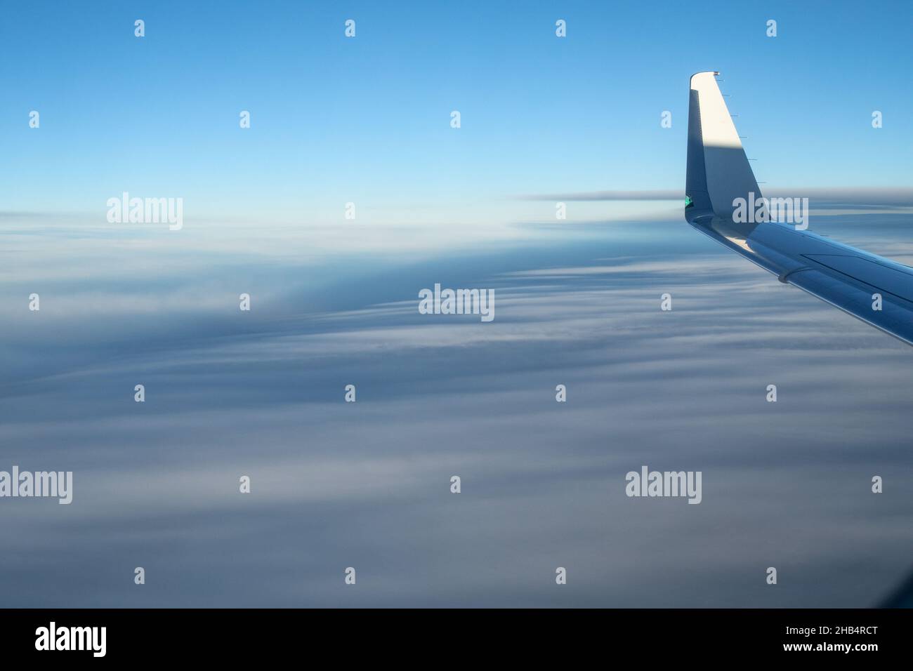 The wing of an Airplane as seen in mid-flight over a cloudy sky Stock ...