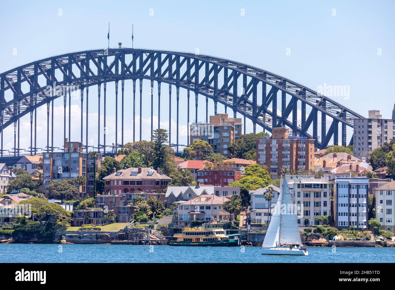 Sailing yacht o Sydney Harbour in front of water homes in Kirribilli and the Sydney Harbour Bridge,sydney,Australia Stock Photo