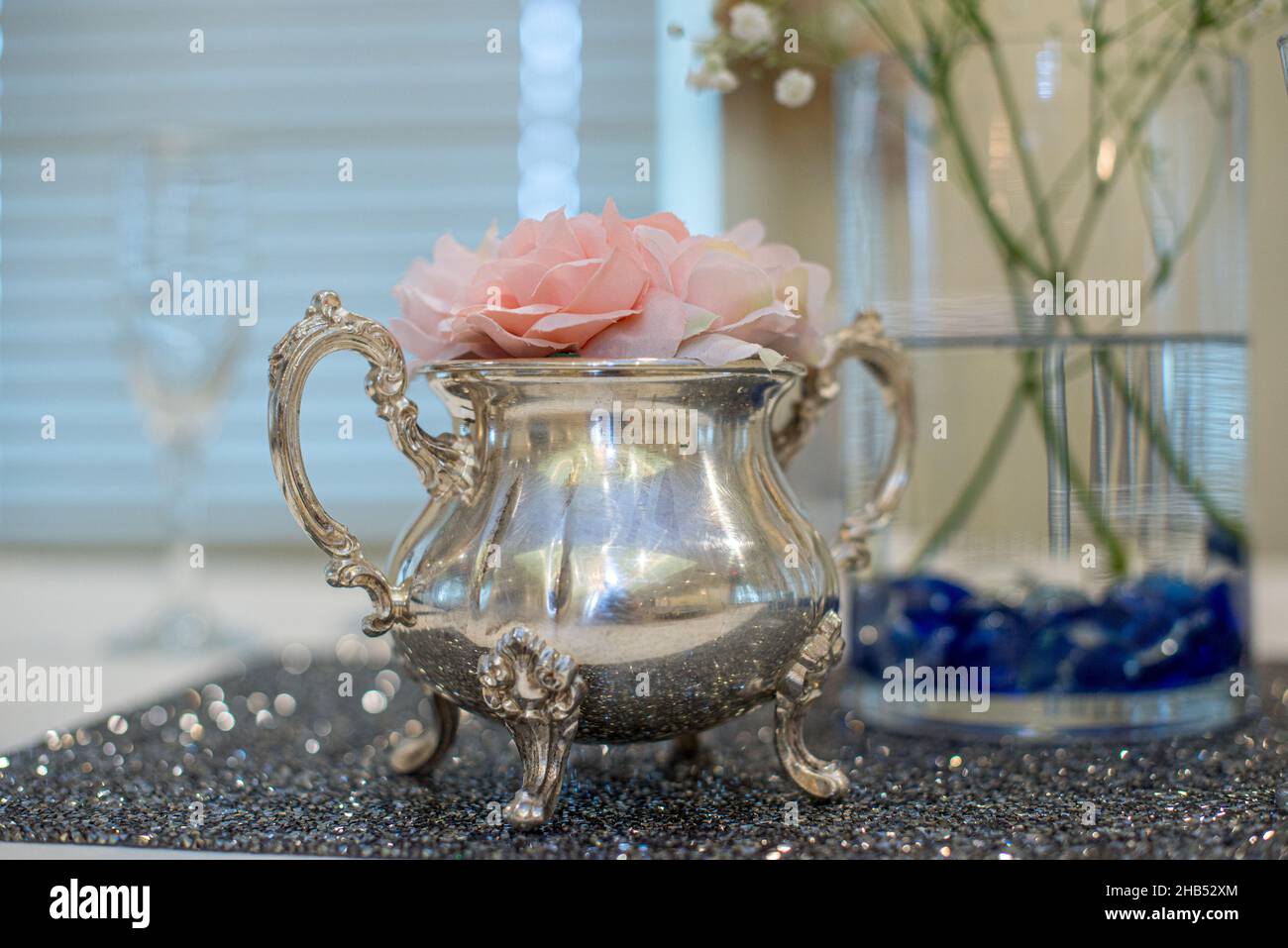 Silver teapot centerpiece with pink roses decor at wedding reception