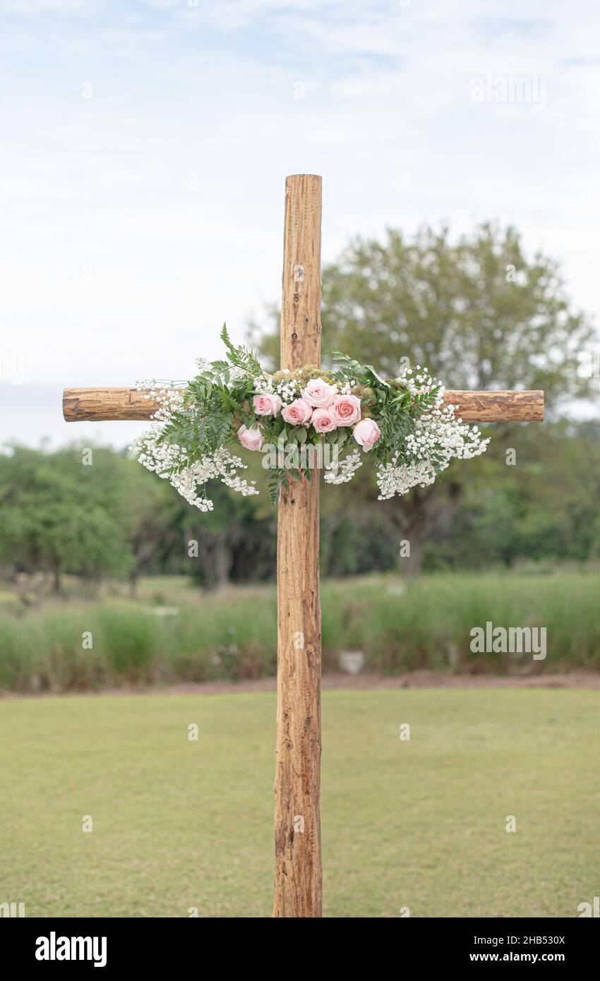 Wooden cross wedding altar with pink roses for outdoor wedding ceremony