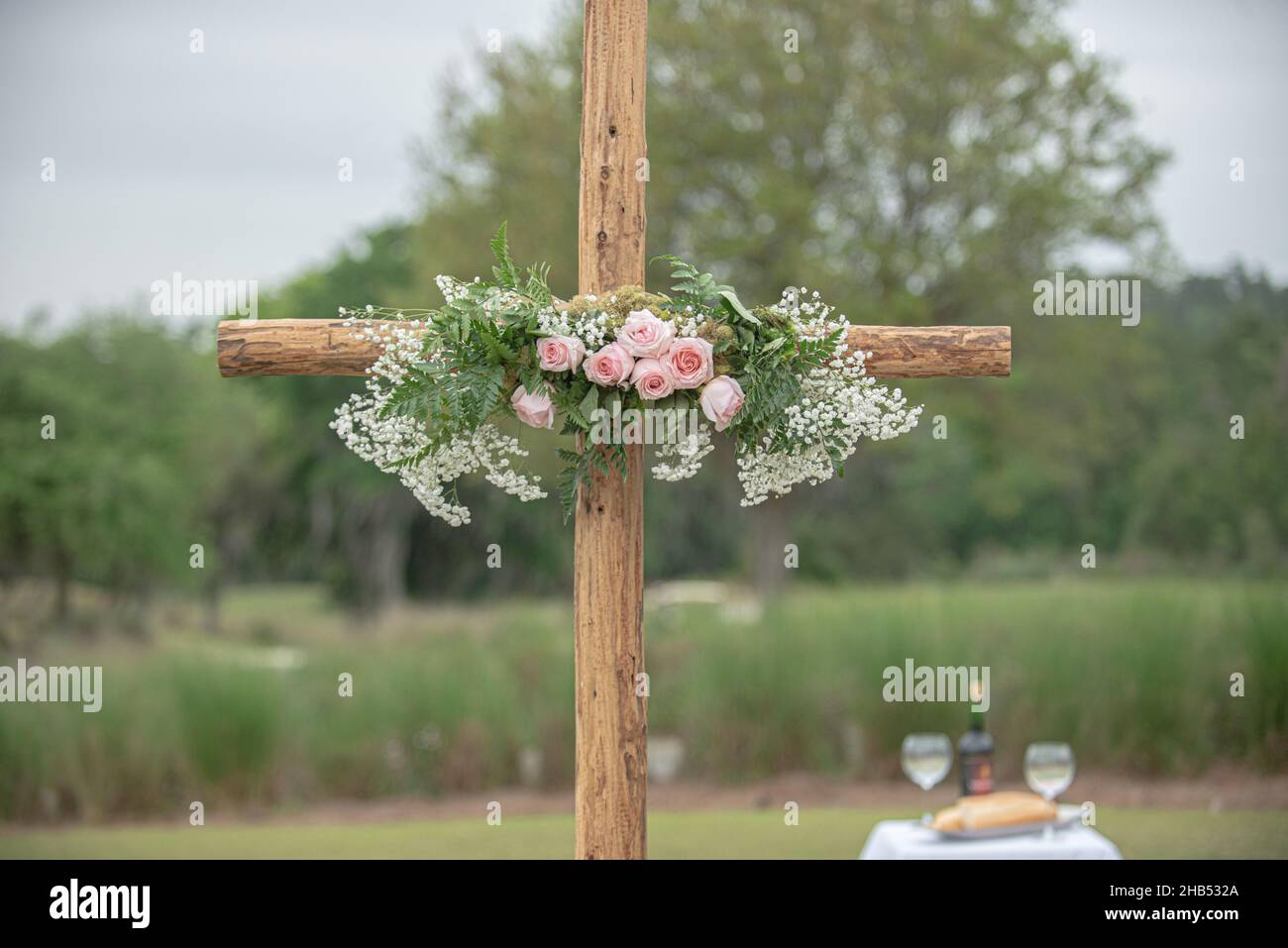 Wooden cross wedding altar with pink roses for outdoor wedding ceremony