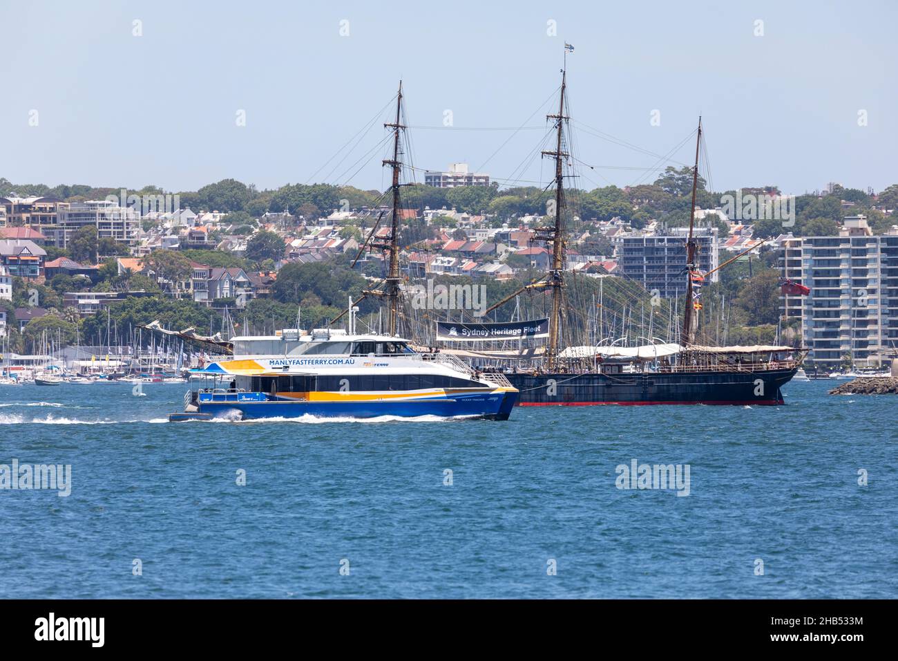 Barque 1874 tall ship the James Craig passes a Sydney ferry, the Manly fast ferry, on Sydney Harbour,NSW,Australia Stock Photo