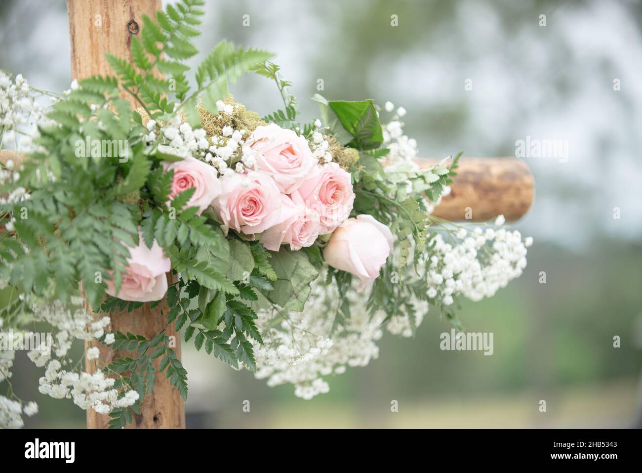 Wooden cross wedding altar with pink roses for outdoor wedding ceremony Stock Photo