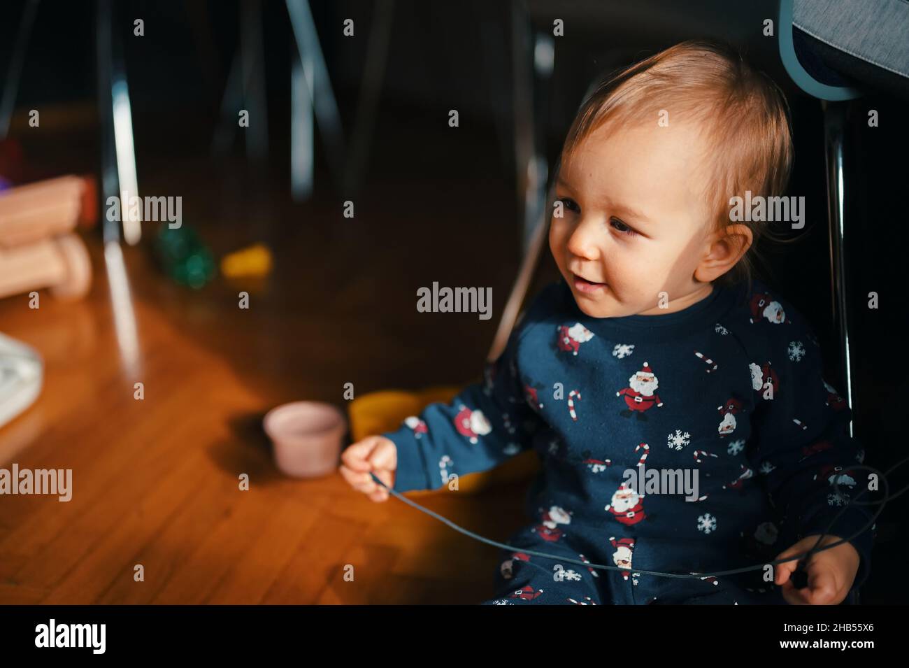 Cute little boy in Christmas costume siting on a floor and playing Stock Photo
