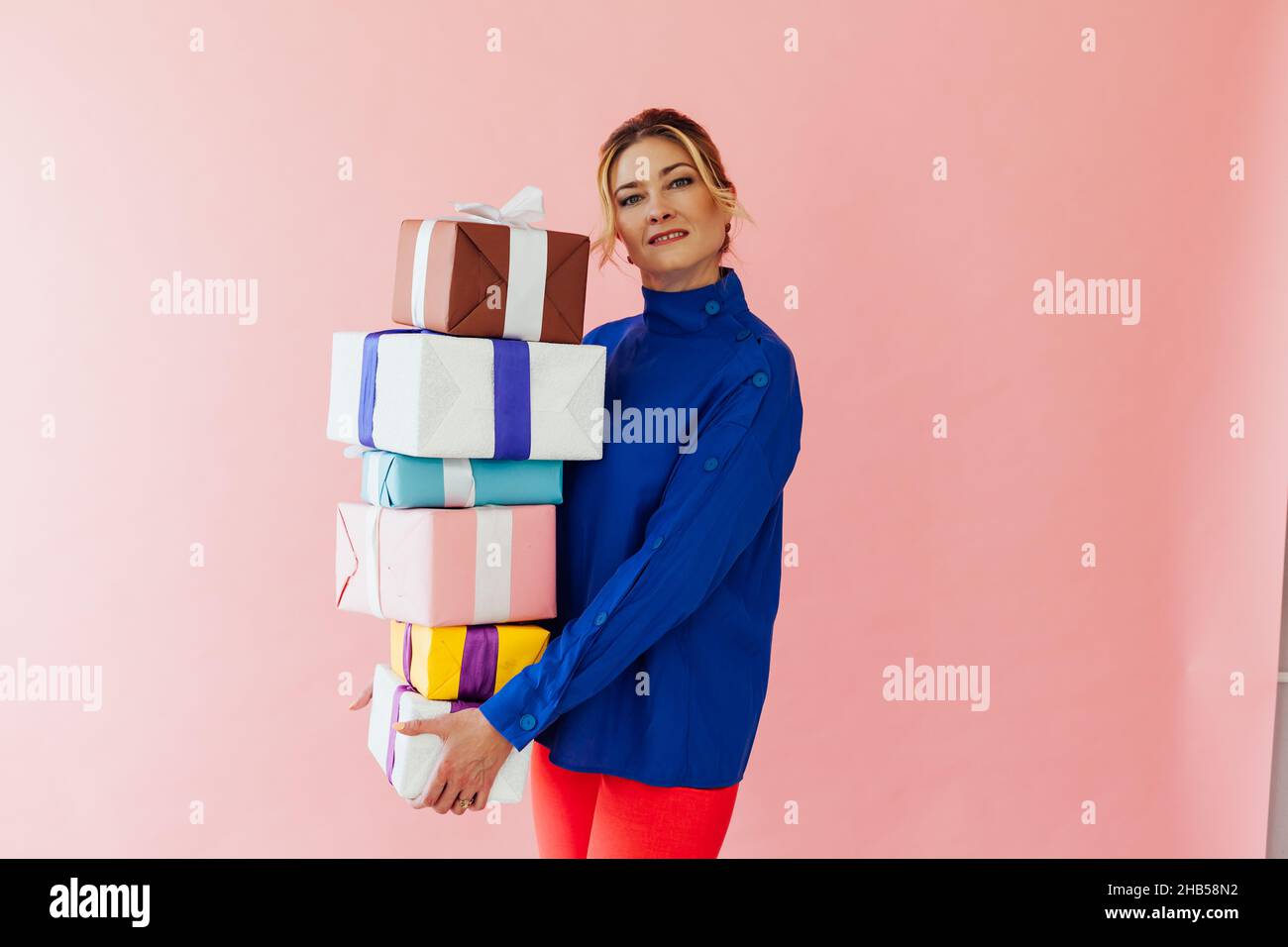 A 40 year old Woman Holds Gifts On A Pink Background Stock Photo Alamy a-40-year-old-woman-holds-gifts-on-a-pink-background-stock-photo-alamy