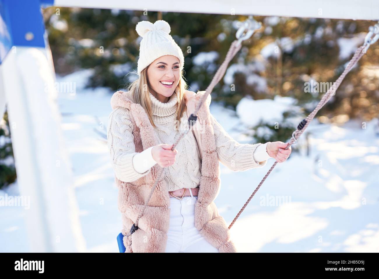 Nice young happy woman in winter scenery on swing Stock Photo