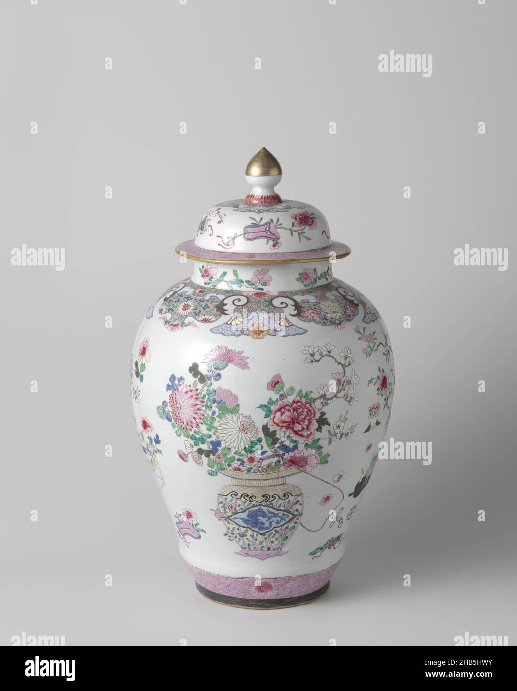 Ovoid covered jar with flower baskets and auspicious symbols, Ovoid covered jar of porcelain, painted in underglaze blue and on the glaze in blue, red, pink, green, black and gold. On the wall twice an openwork handle basket with a chilong (hornless dragon) in a scalloped cartouche. The basket is filled with flower and fruit branches (peony, chrysanthemum, prunus, finger lemon, magnolia). In between also twice a flower vase on a low table. On the vase the head of a shishi (lion dog) with a ring in its mouth. The vase is surrounded by lucky objects (table with scrolls, ruyi scepter, fan, qin Stock Photo
