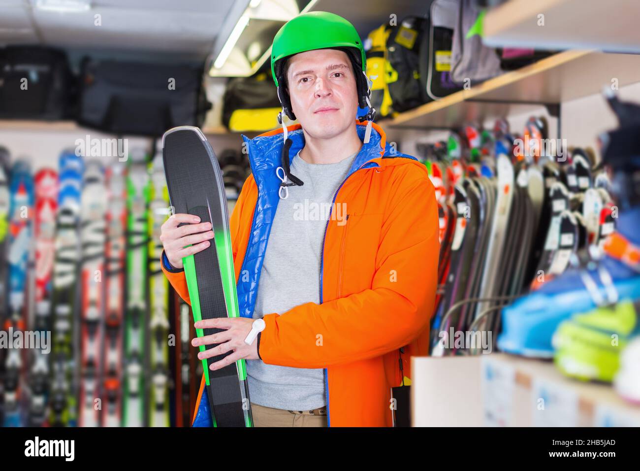 Customer man in ski equipment showing ski in store Stock Photo Alamy