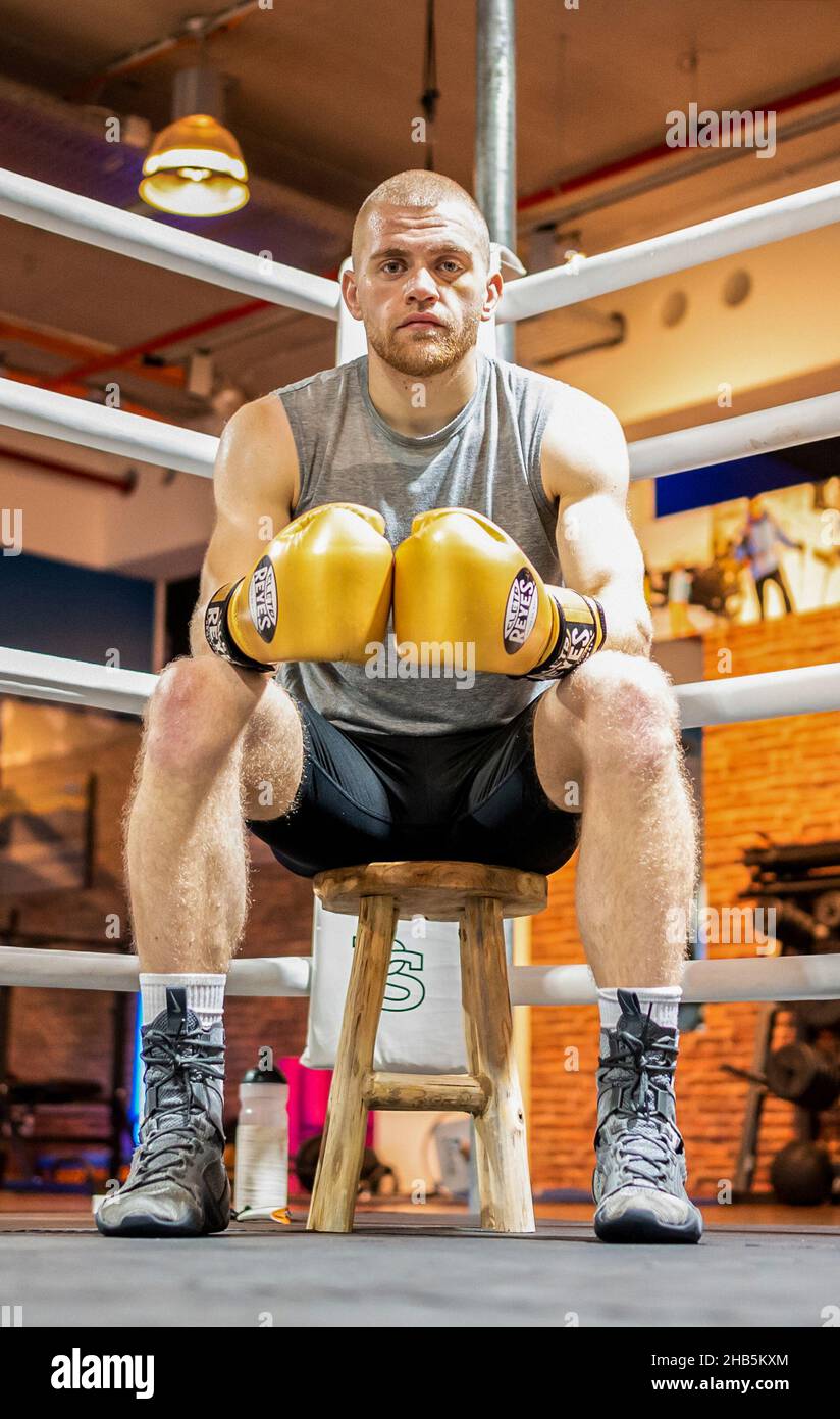 Bispingen, Germany. 13th Dec, 2021. The boxer Joscha Blin sits in the ring. The grandfather of Joscha Blin, Jürgen Blin, boxed against the boxing legend Muhammad Ali, 50 years later the 24-year-old is now facing his first professional fight. (to dpa 'Grandson of Ali opponent before boxing debut: 'Plenty of power in his fists'') Credit: Philipp Schulze/dpa/Alamy Live News Stock Photo