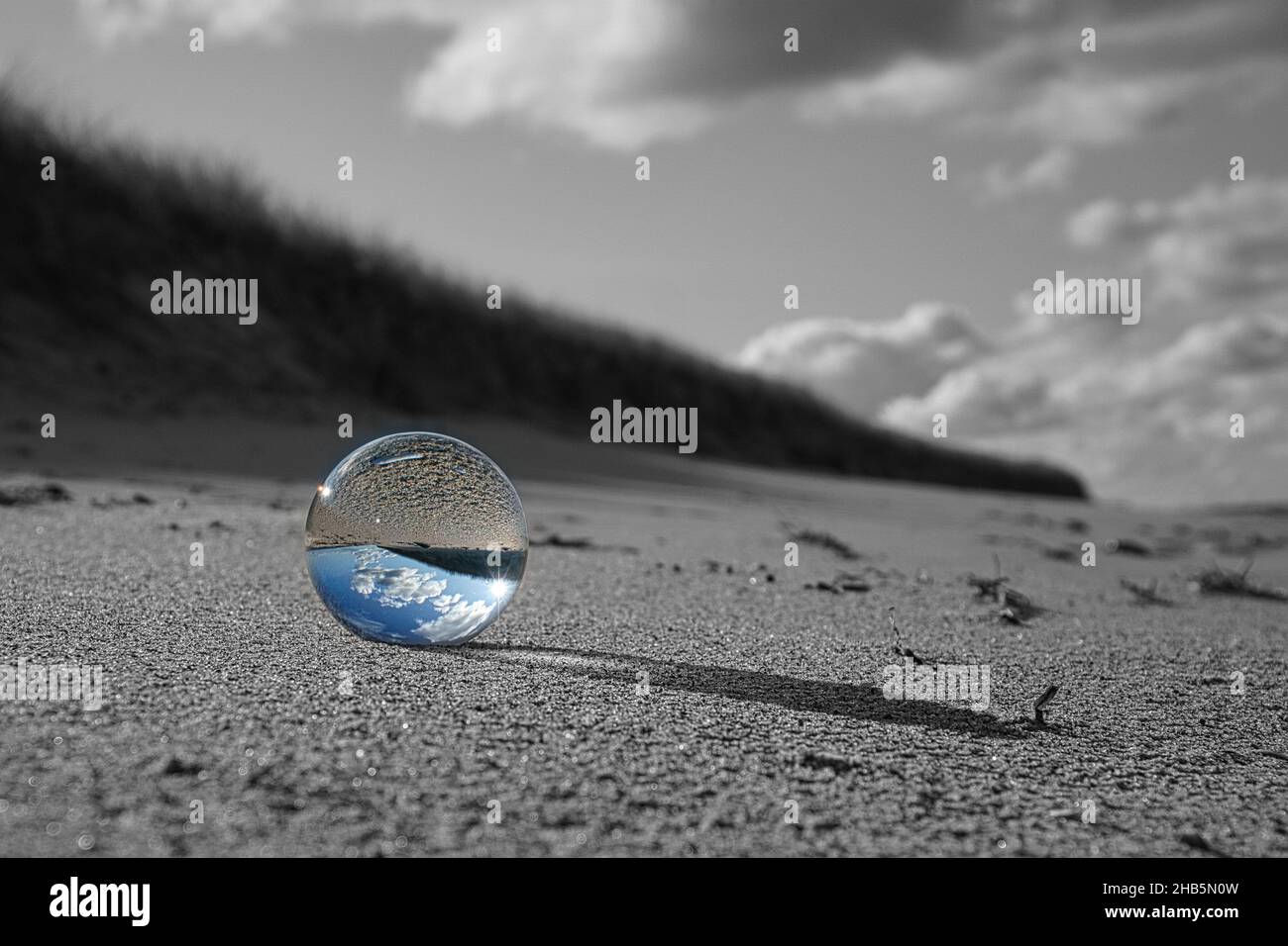 glass globe on the beach of the baltic sea. Black and white photo with ...