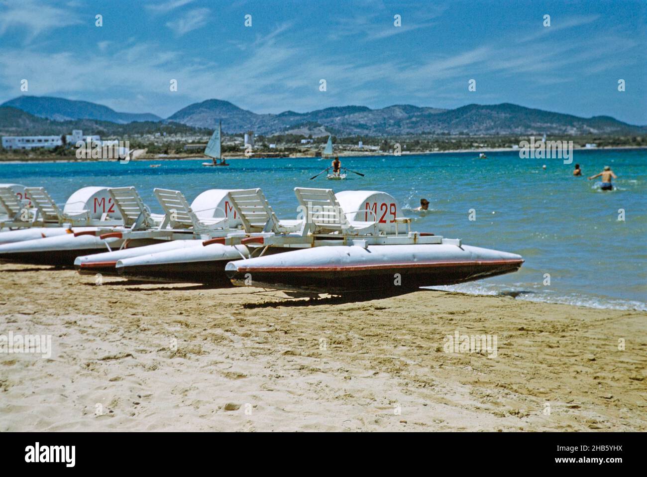 Pedalos people swimming sandy beach, island of  Ibiza, Balearic Islands, Spain, 1950s Stock Photo