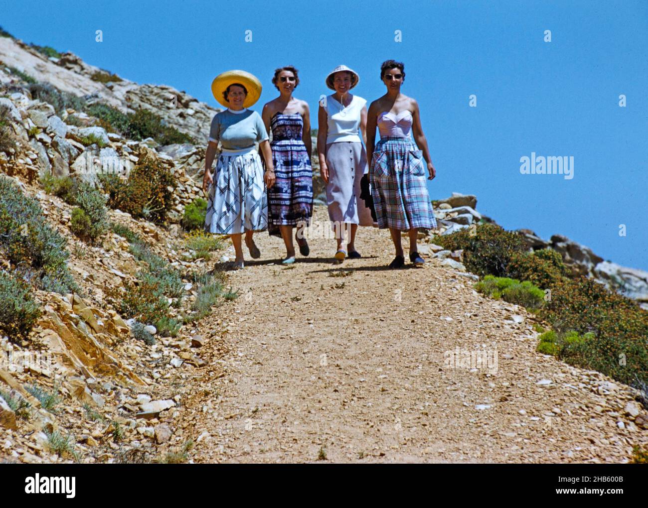 Four women on holiday walking down path on island of Ibiza, Balearic Islands, Spain, 1950s Stock Photo