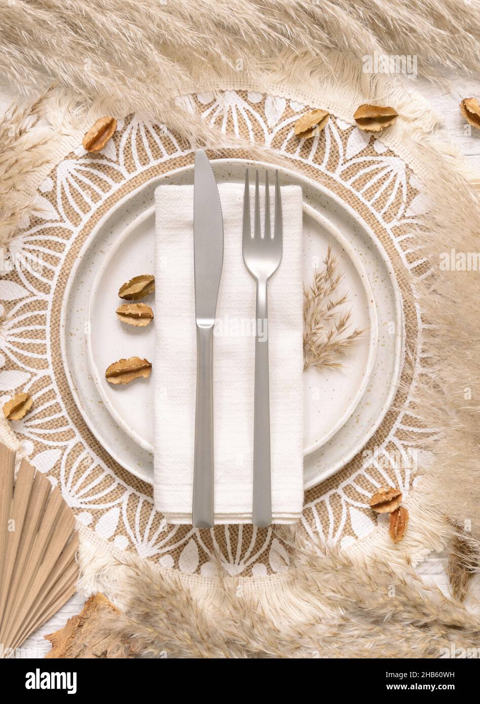 Wedding table place with fork and knife over a napkin on bohemian