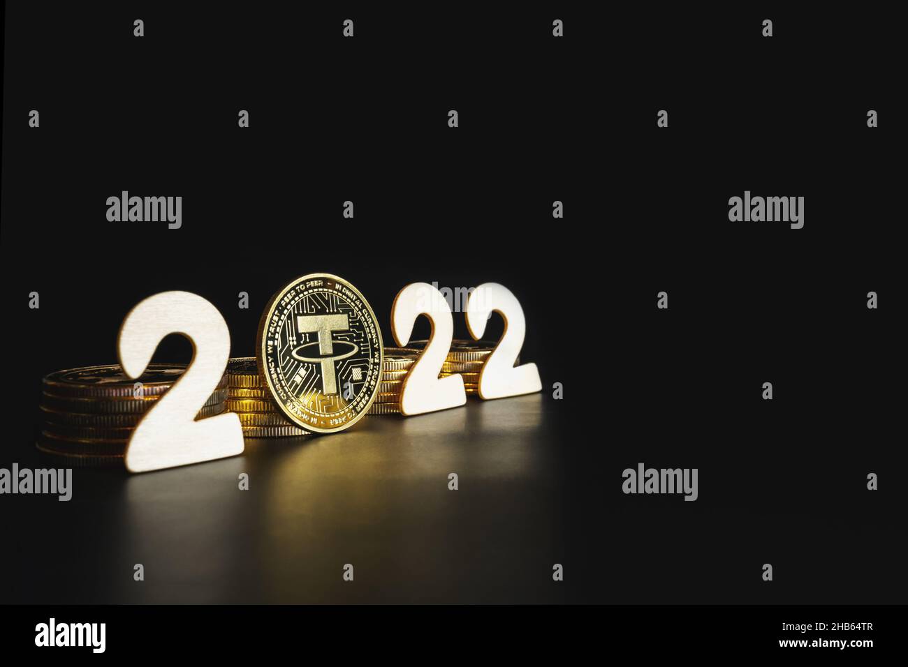 Tether in 2022. Single Tether gold coin next to the year numbers on black background with copy space for text. Value, market cap prediction concept. Stock Photo