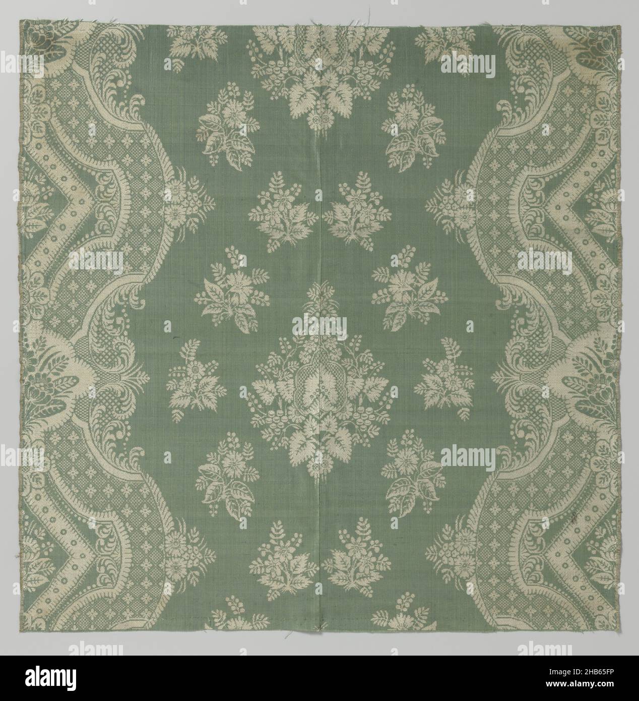Two silk fabric fragments sewn together, Silk fabric consisting of a green warp with ditto weft for the fond (fine rips) and a white warp and weft for the pattern (twill). The pattern consists of a small diamond-shaped bouquet of leaves, around which are loose flower columns like a wreath, surrounded by wide, volute-shaped agrement bands., France, c. 1690 - c. 1710, ketting en inslag: silk, twill, height 50.6 cm × width 50.2 cmheight 29.5 cmwidth 0.3 cm Stock Photo