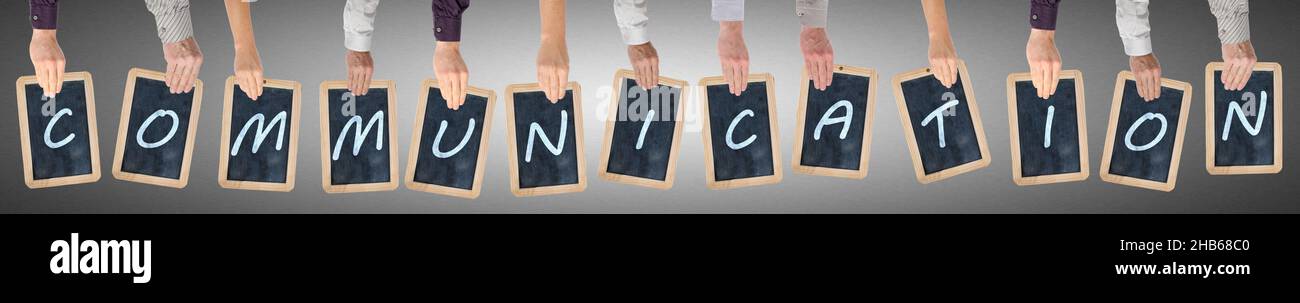 Letters of the word communication written on chalkboards held by hands ...