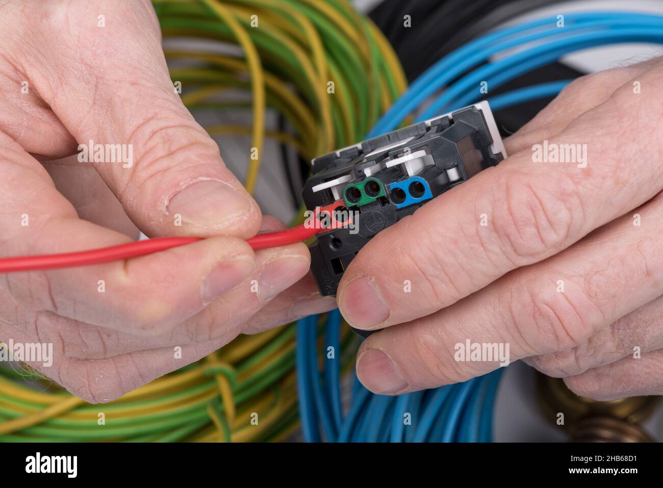 Hand putting a wire in a electrical outlet Stock Photo - Alamy