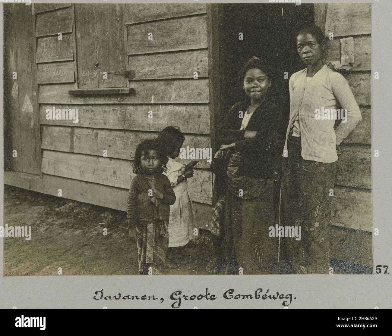 Javanese, Groote Combéweg (title on object), Two Javanese women and two girls standing in the doorway of a wooden house on the Grote Combéweg in Paramaribo. Part of the photo album Souvenir de Voyage (part 2), about the life of the Doijer family in and around the plantation Ma Retraite in Suriname in the years 1906-1913., Hendrik Doijer (attributed to), Suriname, 1906 - 1913, photographic support, gelatin silver print, height 82 mm × width 111 mm Stock Photo