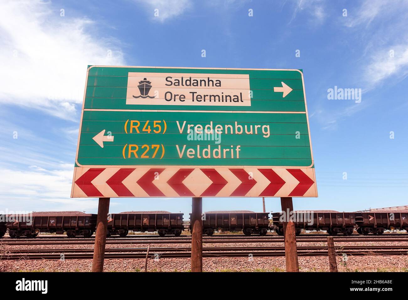 Road sign for the Saldanha ore terminal and train wagons or iron ore Stock Photo