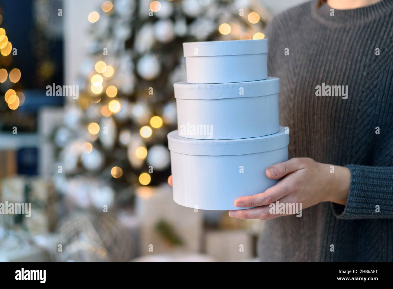 Woman holding stack gift boxes with Christmas decorations Stock Photo