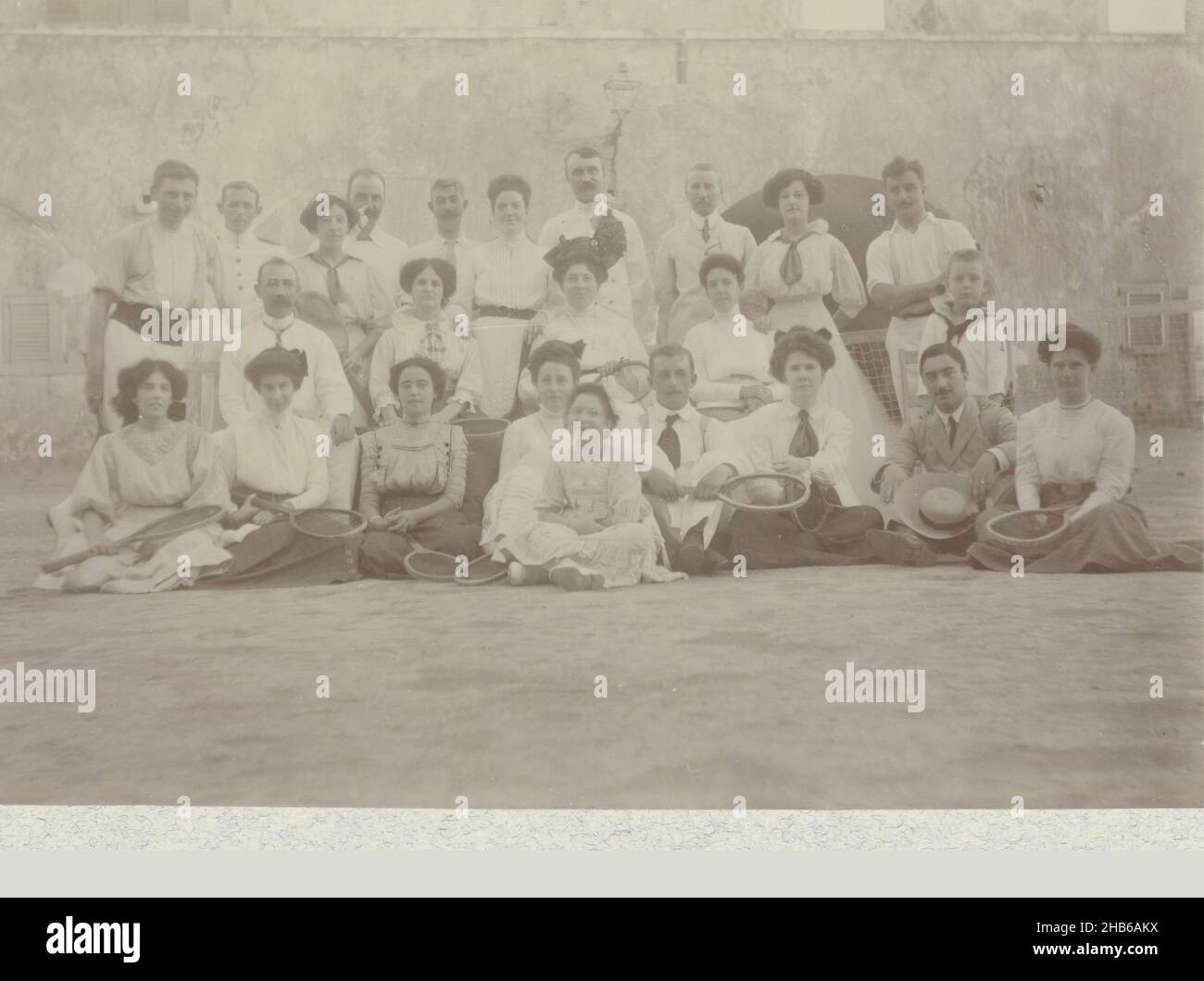 Tennis Club, Group photo of members of a tennis club, probably in Curaçao. Third from the right in the back row is Andries Boom. Next to the photo the names of most of the individuals. The men in the caption indicated by their rank in the Navy. Ca. 1910-1911. Part of the photo album of the Boom-Gonggrijp family in Suriname and Curaçao., Andries Augustus Boom, anonymous, Curaçao, 1910 - 1911, photographic support, height 81 mm × width 109 mm Stock Photo