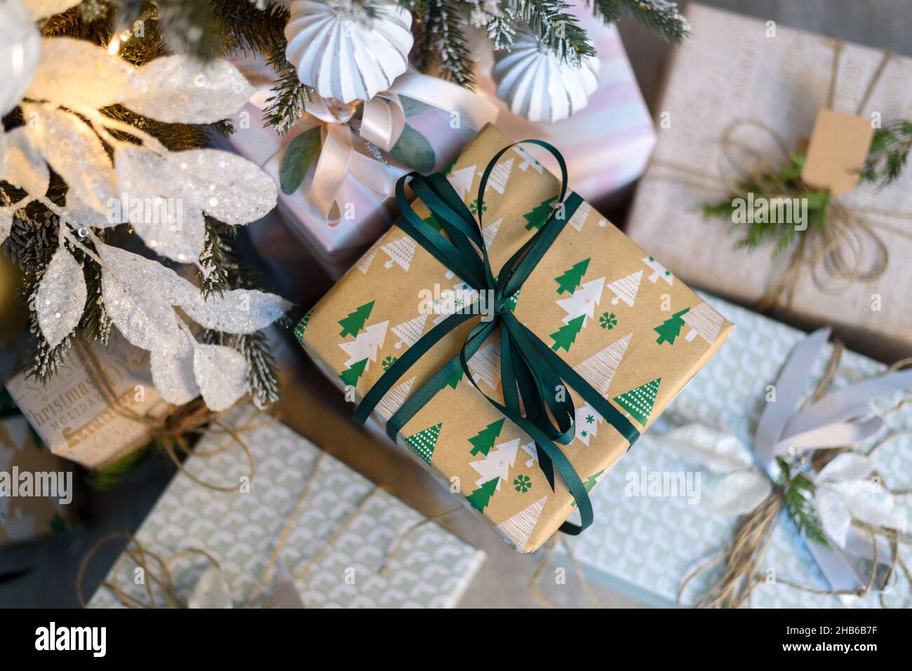 Wrapped in craft paper gift boxes near Christmas tree Stock Photo