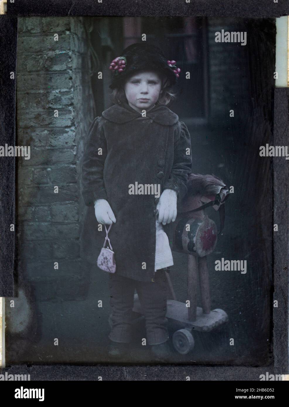 Paget process colourised magic lantern slide portrait of a young girl dressed up in adult clothing, circa 1900 Stock Photo