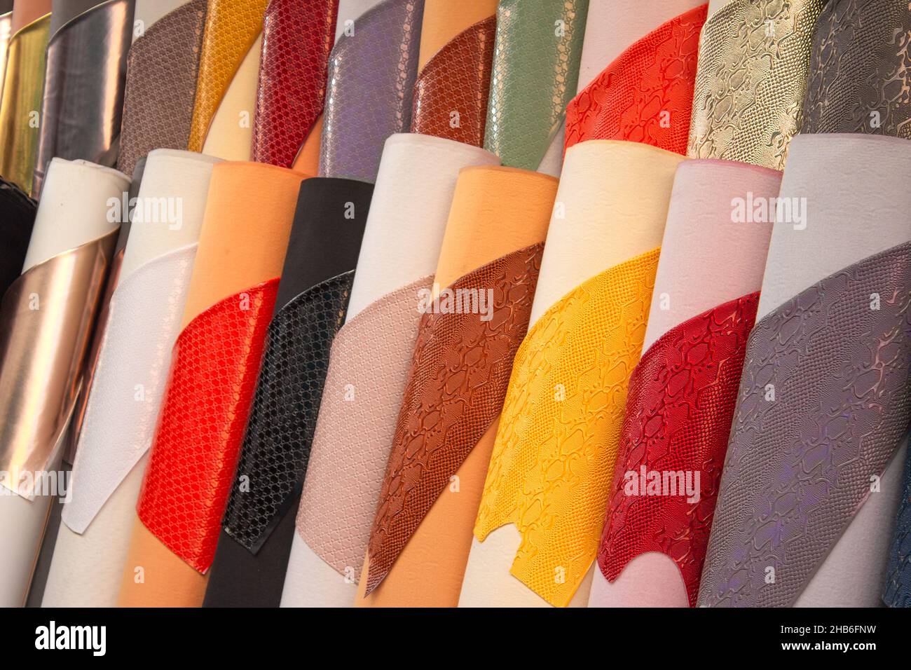 Artificial synthetic leather of high quality in rolls. Snake and crocodile artificial embossed leather. Selective focus. Eco leather concept Stock Photo