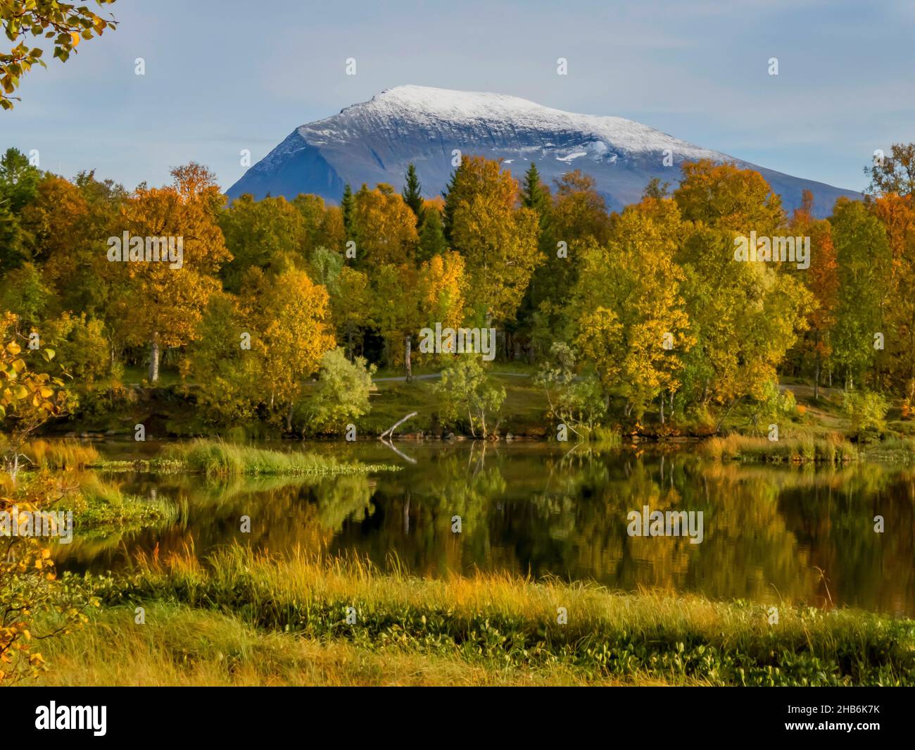autumnal colours at lake Prestvannet, snow capped Tromsdalstinden mountain in background, Norway, Troms, Tromsoe Stock Photo