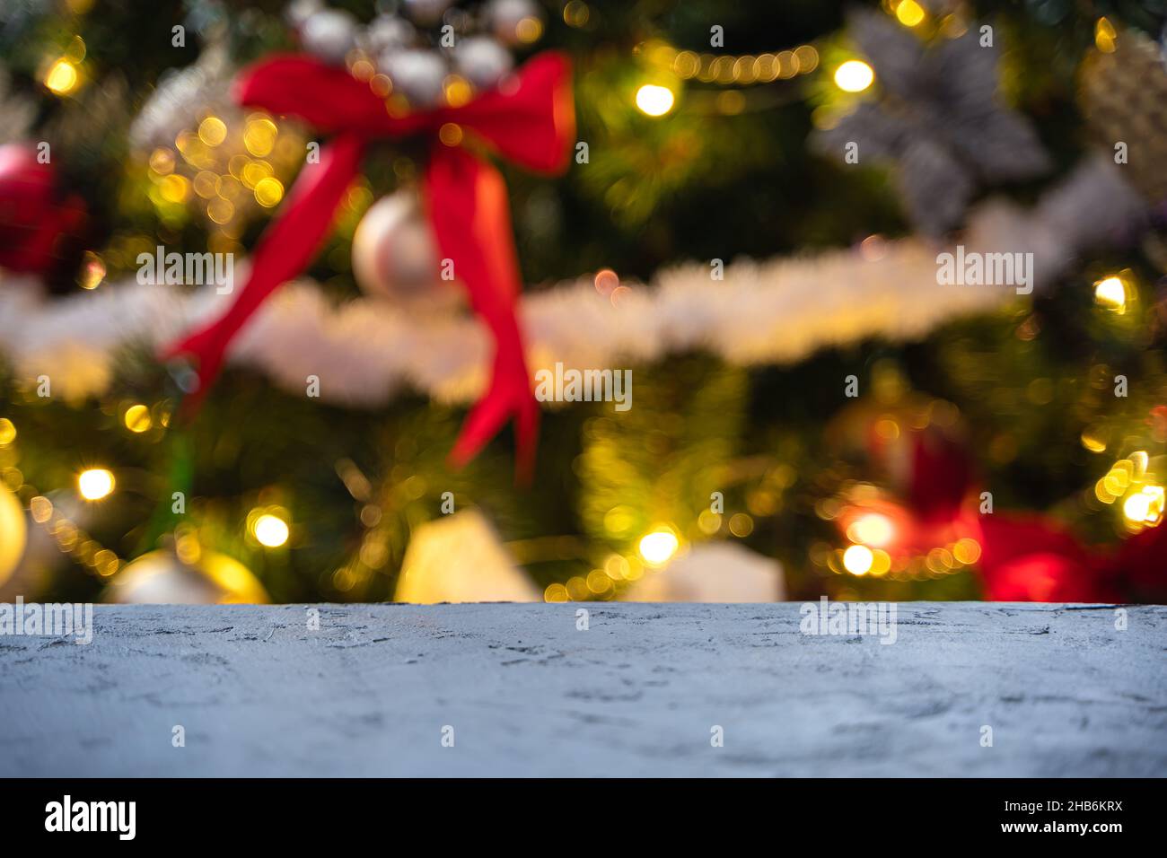 Christmas background with a table on the background of a decorated Christmas tree. Unfocused. Side view. Stock Photo