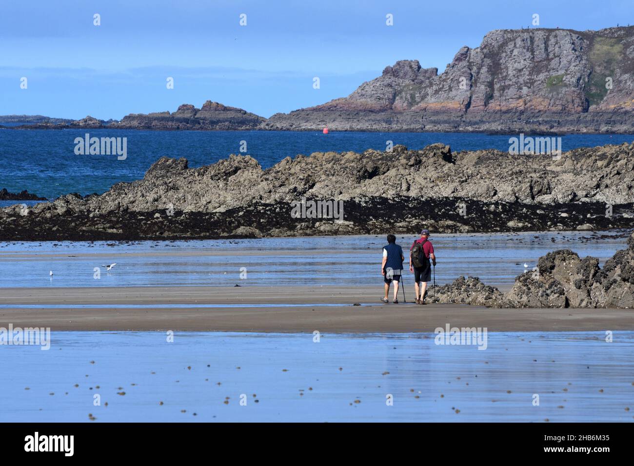 two hikers on Caroual beach , France, Brittany, Departement Cotes-d’Armor, Erquy Stock Photo