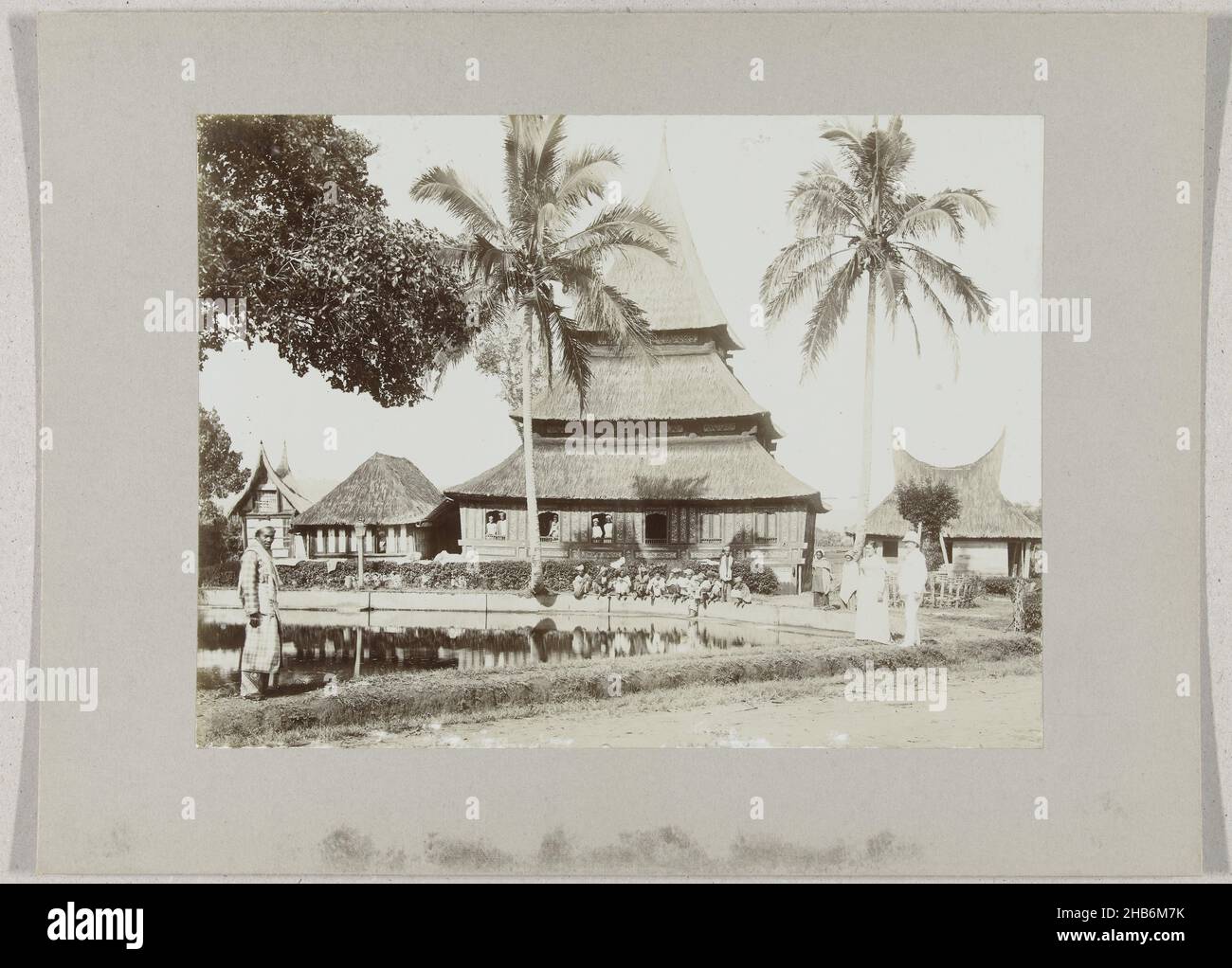 Mosque with fish pond in Kampong Taloek near Fort de Kock6. Fishpond Fort de Kock (title on object), Mosque with fishpond at Kampong Taloek near Fort de Kock, Sumatra, Dutch East Indies. On the right a Western couple, children near the edge of the pond., anonymous, Sumatra, c. 1895 - c. 1915, photographic support, paper, gelatin silver print, height 180 mm × width 240 mmheight 243 mm × width 329 mm Stock Photo