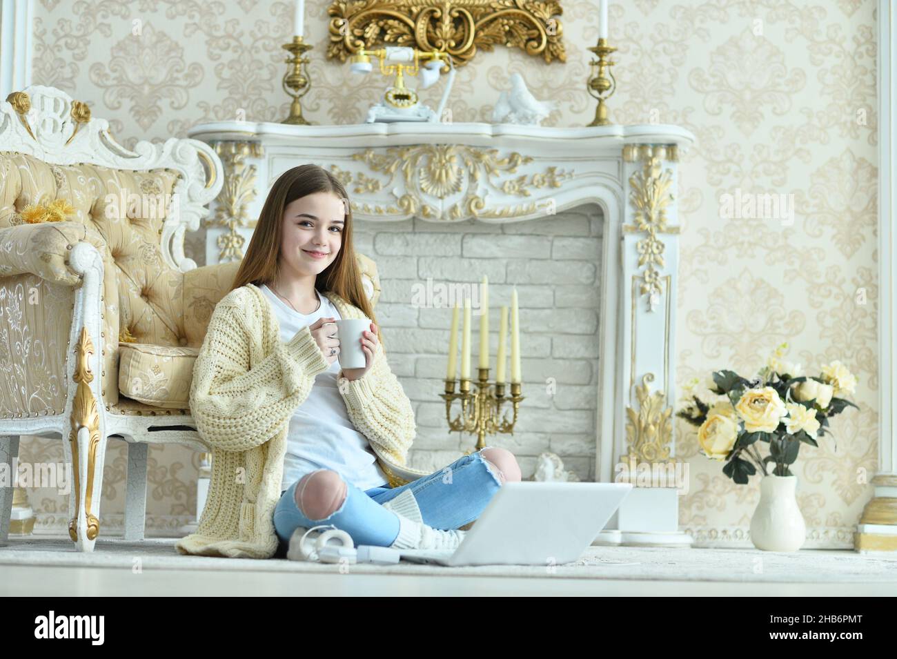 Beautiful teen girl sitting on floor near vintage armchair Stock Photo ...