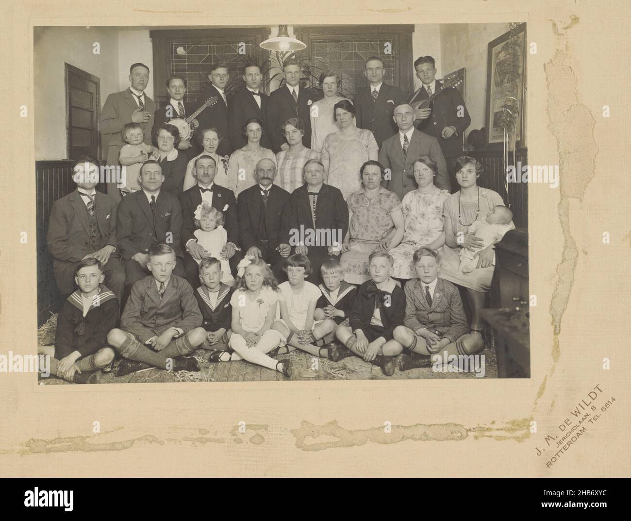 Family portrait, with stringed instruments, Johannes Matthijs de Wildt, Rotterdam, c. 1920 - c. 1930, cardboard, paper, gelatin silver print, height 170 mm × width 236 mm Stock Photo