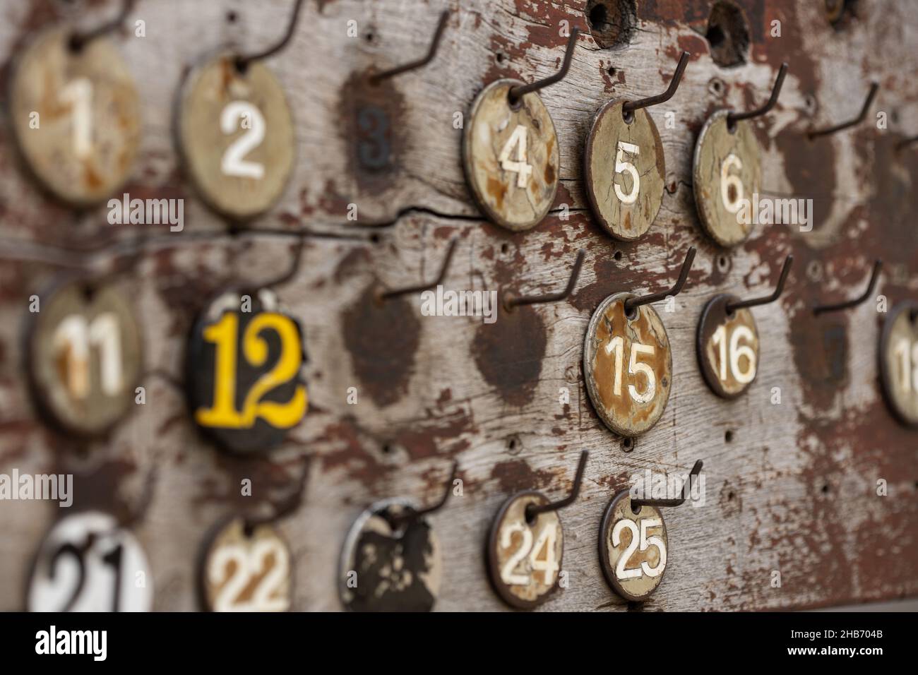 Selective shot of numbers hanging on a rusty weathered board Stock Photo
