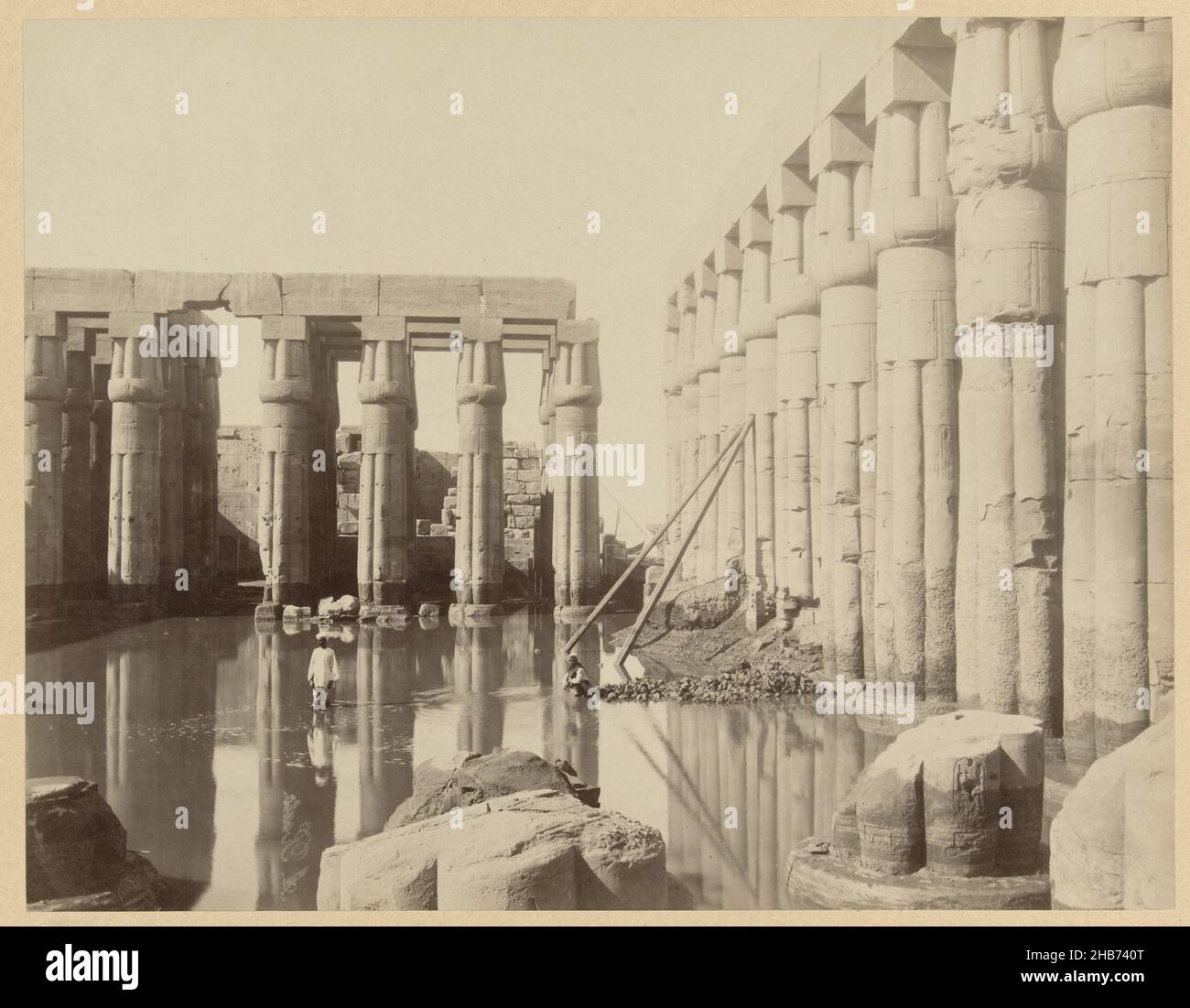 The temple complex of Luxor partially submerged by high water level of the Nile.E 75. Temple of Luxor at high water level of the Nile. Upper Egypt. (title on object), The photograph is part of the series of photographs from Egypt collected by Richard Polak., Antonio Beato (mentioned on object), Egypte, c. 1895 - c. 1915, photographic support, paper, albumen print, height 219 mm × width 278 mmheight 466 mm × width 555 mm Stock Photo