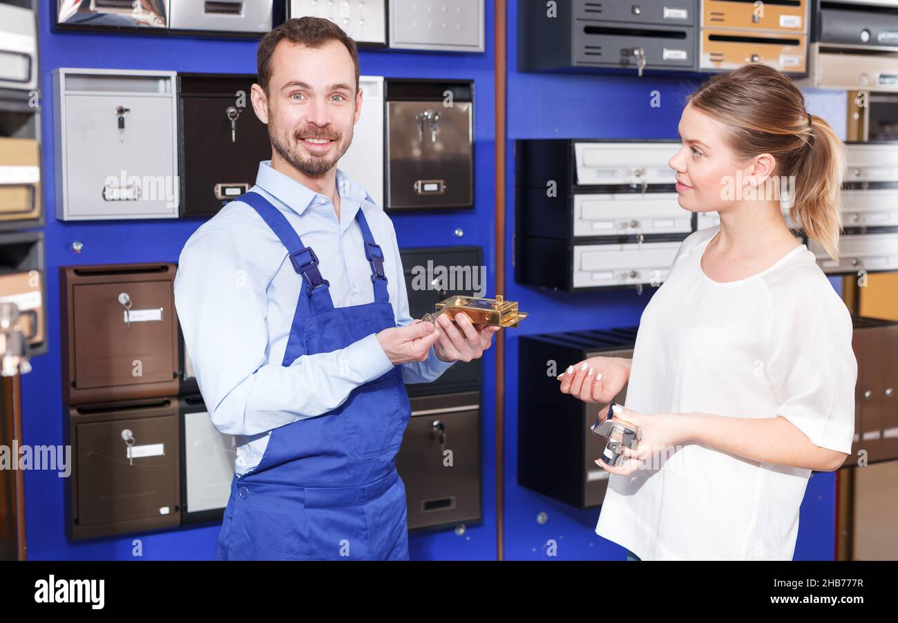 Worker showing door lock to female client Stock Photo Alamy