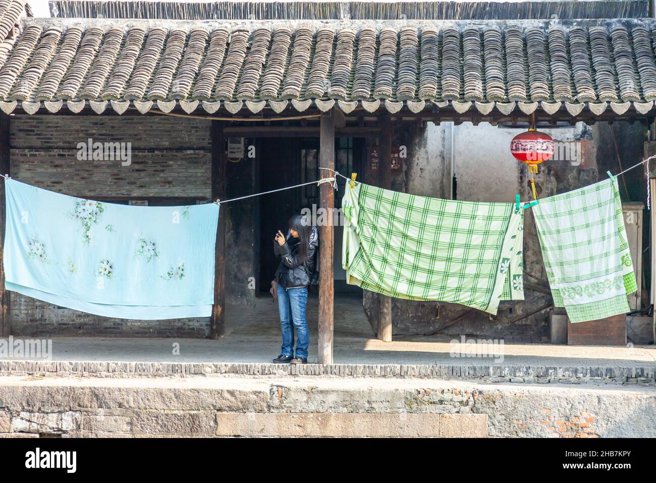Lady photographing, laundry, red lantern. Xitang, China Stock Photo