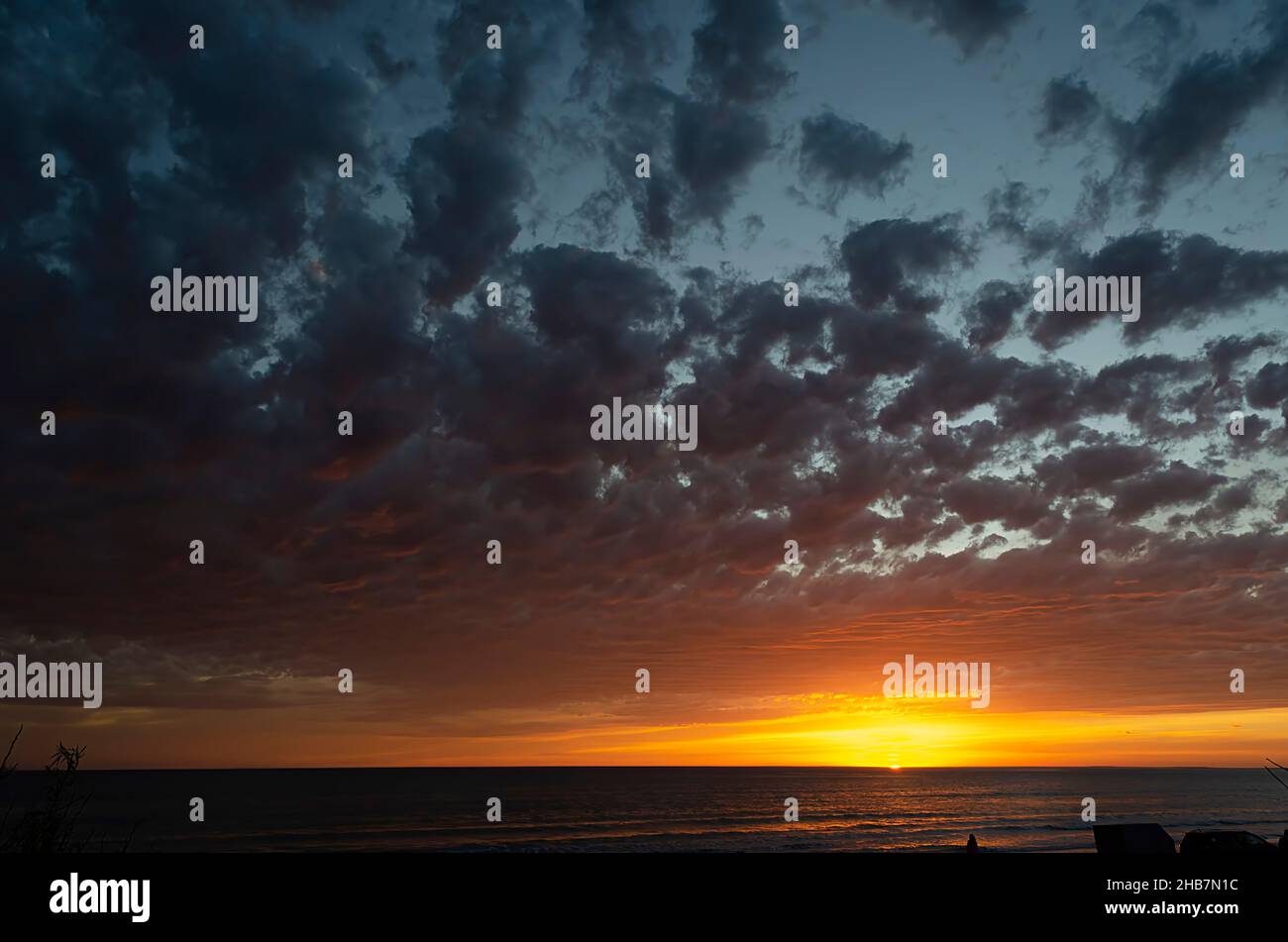 Fiery sunset on the sea. The silhouette of a ship is visible on the ...