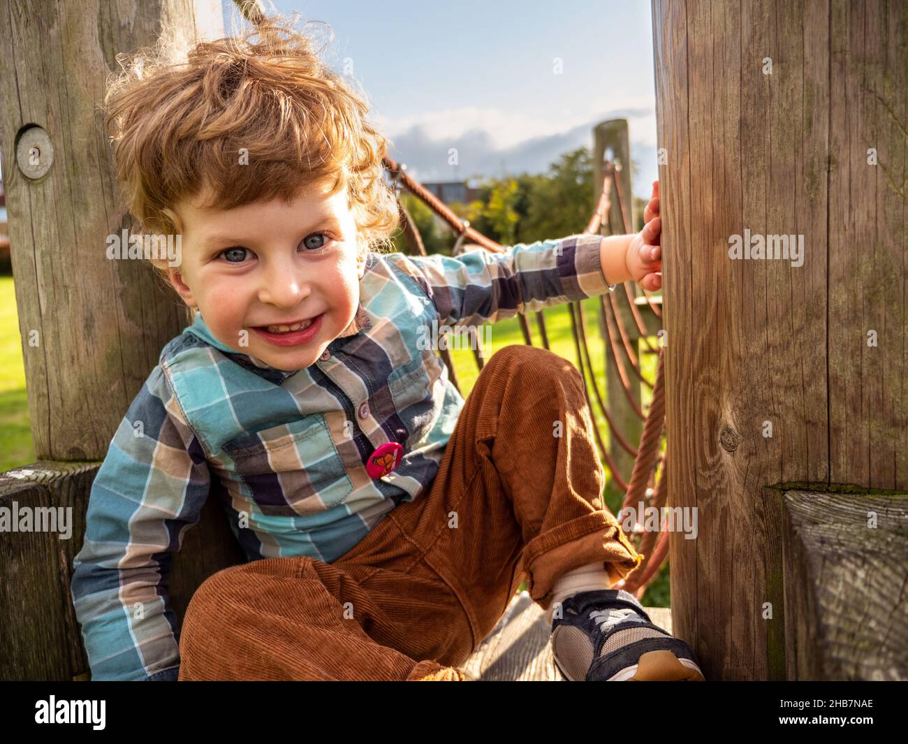 Happy smiling two year old boy child having fun playing outdoors at the playground Stock Photo