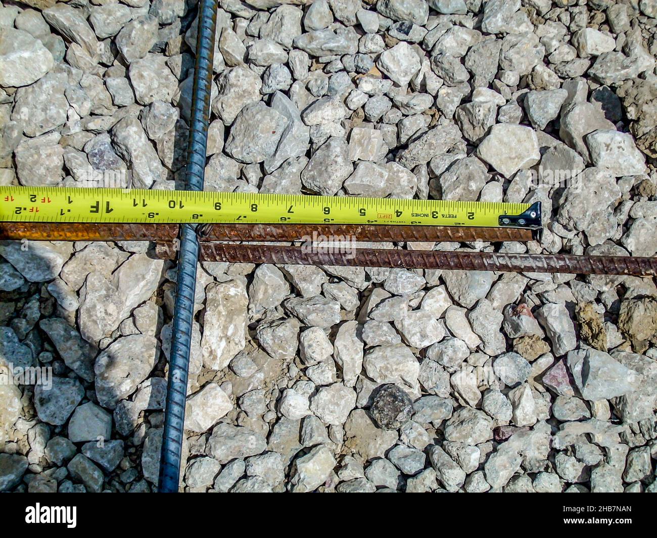 Inspecting and documenting the rebar overlap with a measuring tape at a