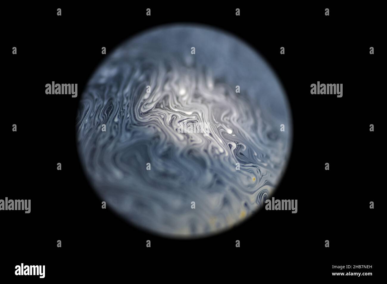 Grey colored cold alien planet, spotlighted by the sun with an atmosphere in universe on dark background. Soap bobble Stock Photo
