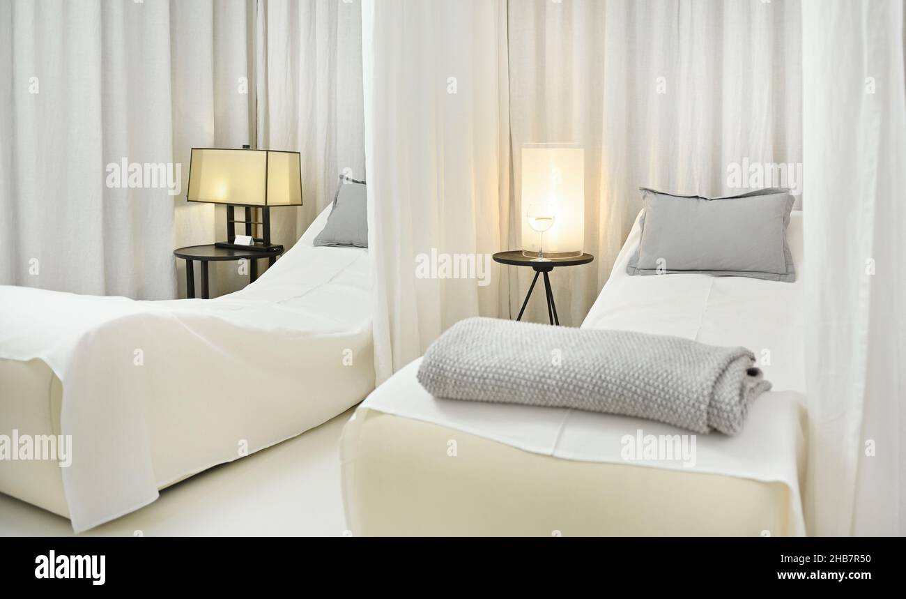 Beautiful luxurious white interior of a private massage room with two beds for two people to relax and in a modern wellness spa Stock Photo