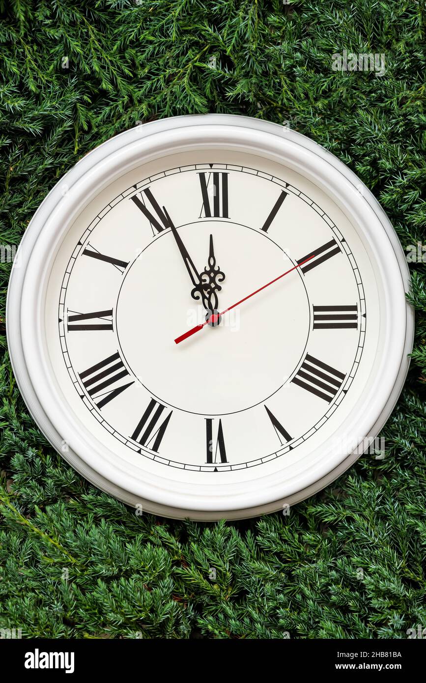 Half part of white clock on fir tree branches as background Stock Photo ...