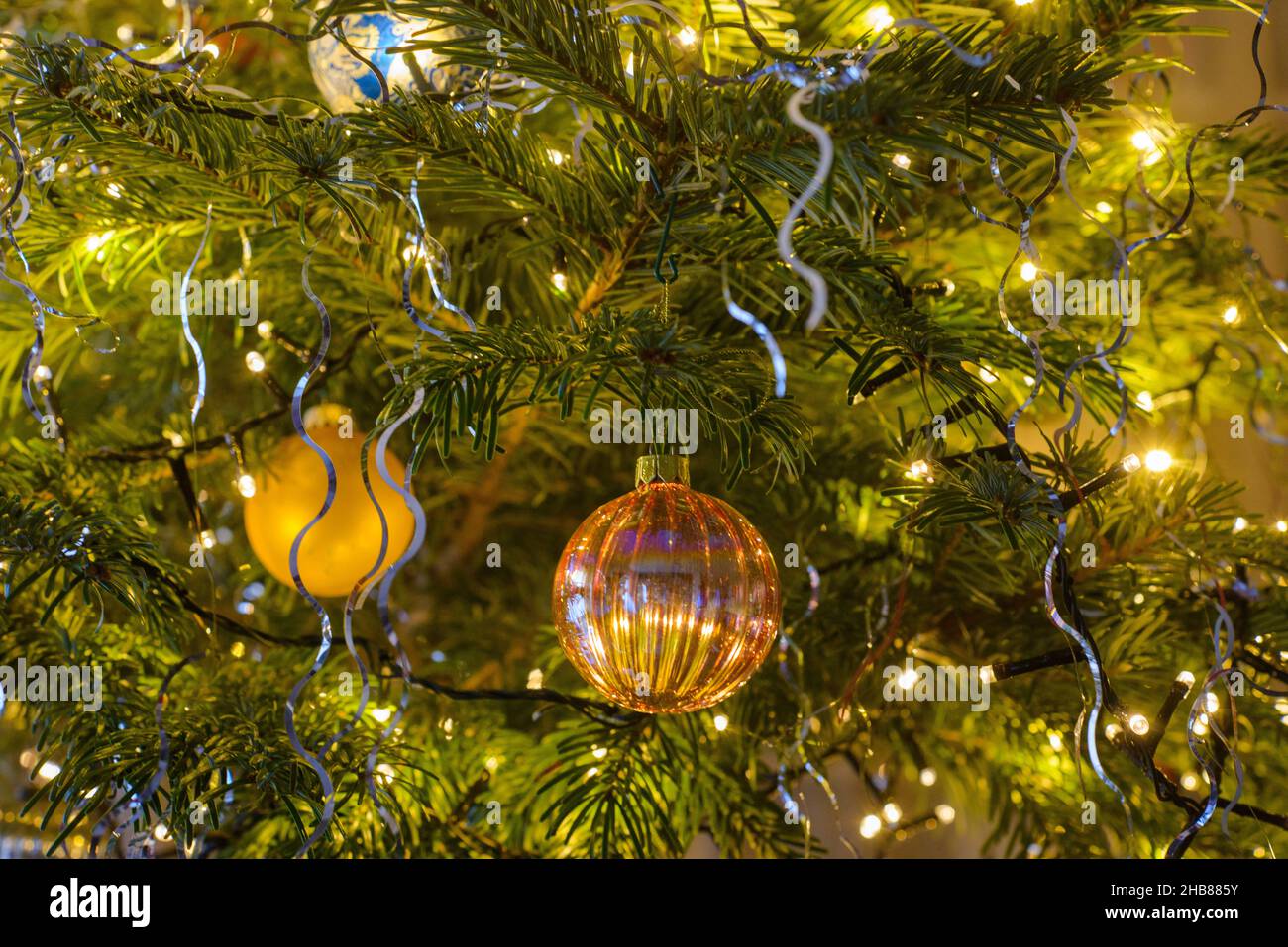 décorations et boules de noël sur un sapin pendant les fêtes de fin d'année. Christmas decorations and baubles on a tree during the festive season. Stock Photo
