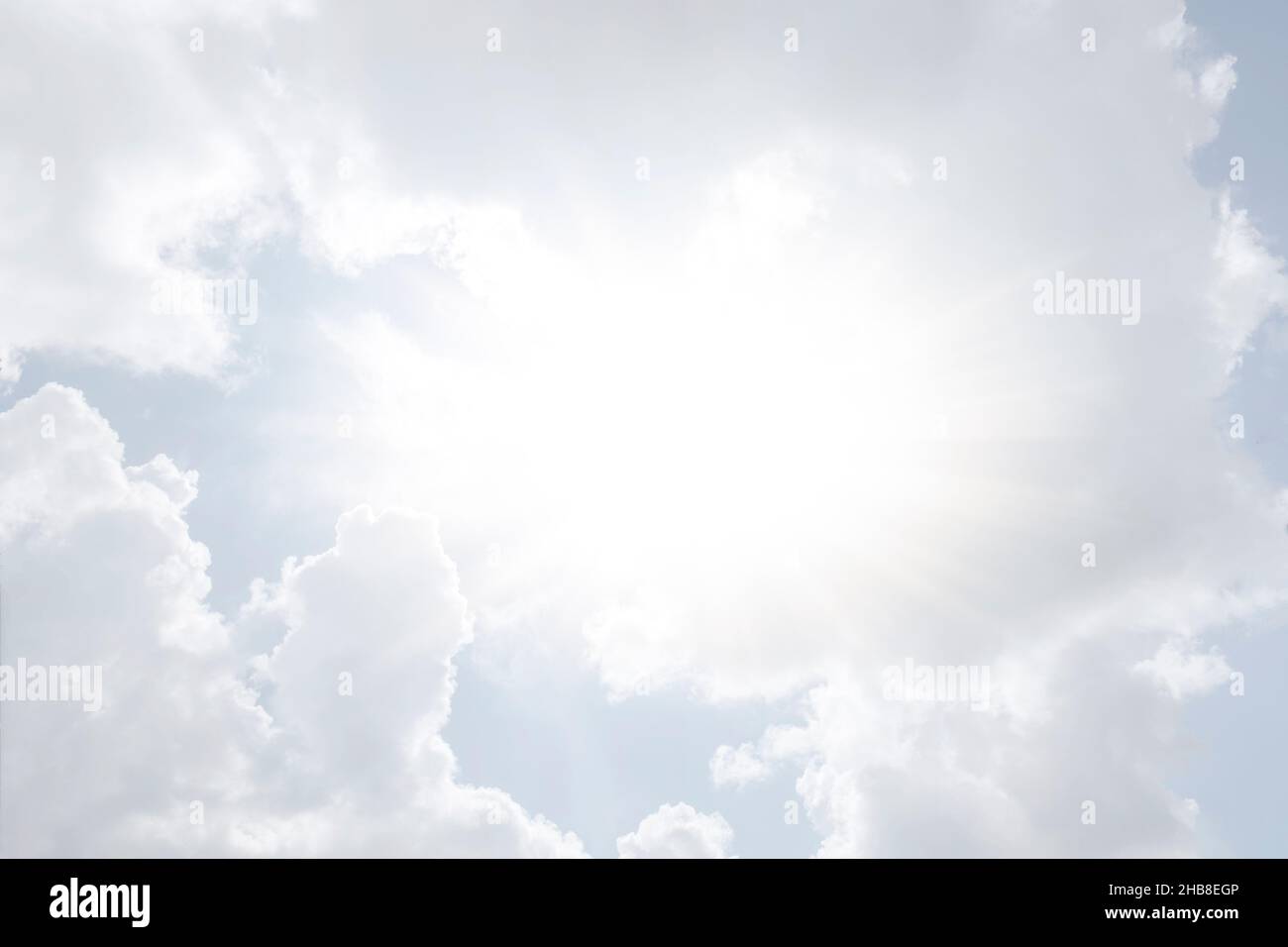 Sun shining through white clouds Stock Photo